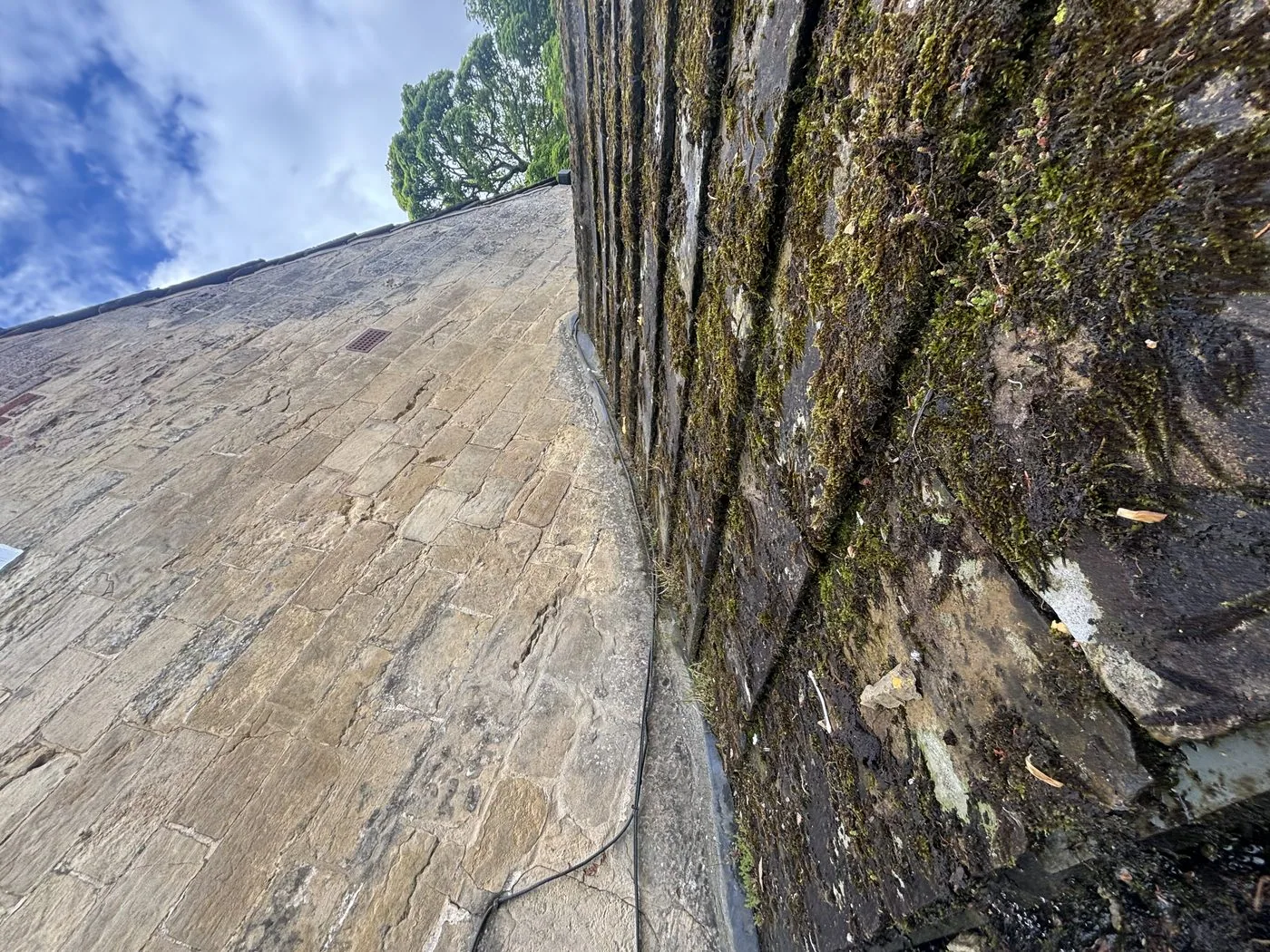 Stone slate roof at 118 High Street Knaresborough before cleaning — heavy moss growth